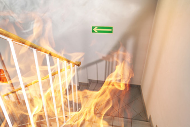 Oheň na schodisku, na stene šípka pre únik