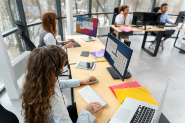 Pracovníci call centra so slúchadlami pri počítačoch