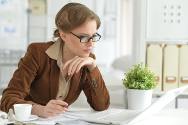 Mladá žena premýšľa u notebooku