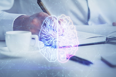 Človek píše a v popredí je schéma umelej a ľudskej polovice mozgu