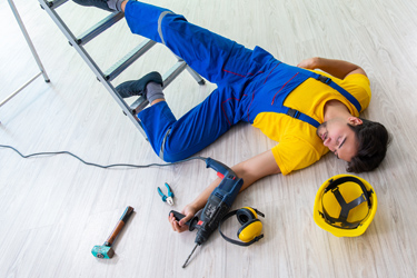 Muž s vŕtačkou leží zranený pod rebríkom