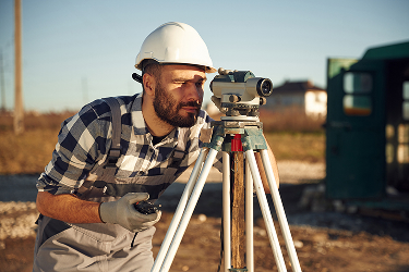Geodet vymeriava na stavbe
