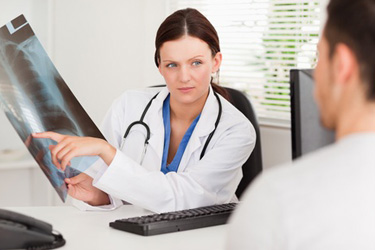 Doktorka ukazuje pacientovi RTG snímku Doktorka ukazuje pacientovi RTG snímku