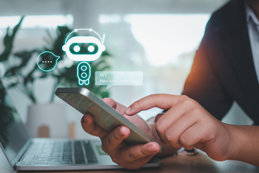 Človek si píše cez mobil s chatbotom