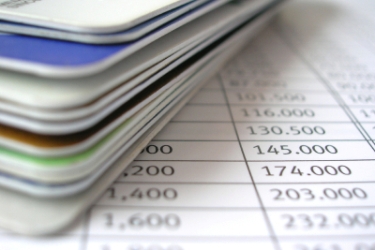 Balík bankových kariet leží na tabuľke so sumami